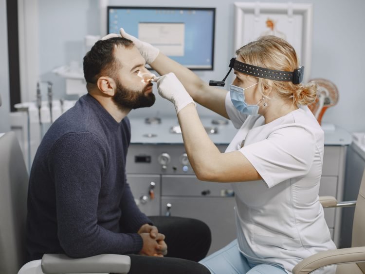 Man patient in the medical office. Doctor in medical mask.